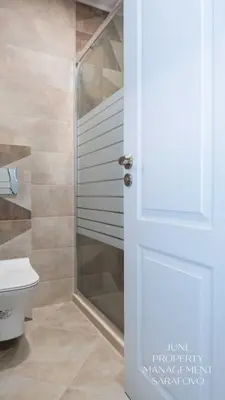 a bathroom with a shower and a white door at Sea-breeze retreat Zerini in Burgas City