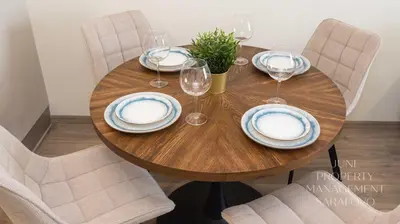 a wooden table with plates and wine glasses on it at Sea-breeze retreat Zerini in Burgas City