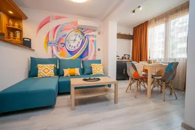 a living room with a blue couch and a table at Бургаски вечери Burgas nights in Burgas City