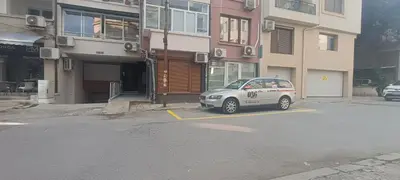 a car parked in a parking lot in front of a building at Бургаски вечери Burgas nights in Burgas City