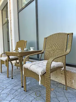 two wicker chairs and a table on a patio at Villa Roma Gs' Apartment in Nesebar