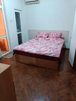a bedroom with a bed with pink pillows on it at Апартамента на центъра на Варна до фонтаните in Varna City