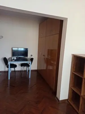 a room with a desk and a table and a cabinet at Апартамента на центъра на Варна до фонтаните in Varna City