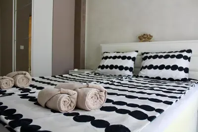 a bedroom with a bed with towels and pillows at Cozy by the Sea in Burgas City