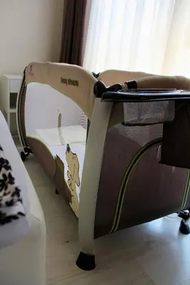 a small bed in a room with a crib at Cozy by the Sea in Burgas City