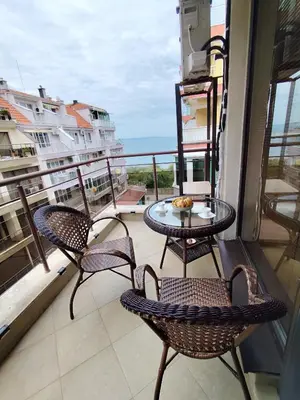 a balcony with a table and chairs and a view of the ocean at Villa Alva in Pomorie