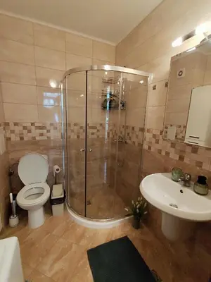 a bathroom with a shower and a toilet and a sink at Villa Alva in Pomorie
