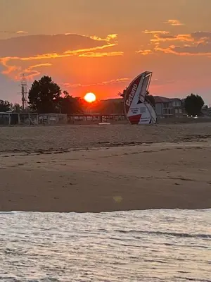 a sail boat on the beach at sunset at Апартаменти за гости Морска гледка in Chernomorets