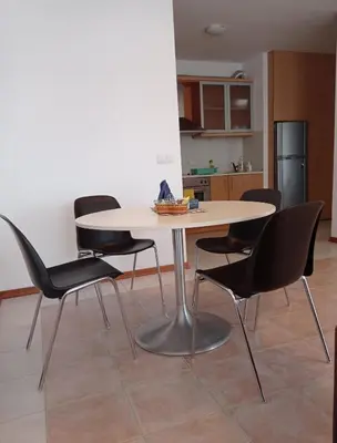a dining room table with four chairs in a kitchen at Апартаменти за гости Морска гледка in Chernomorets