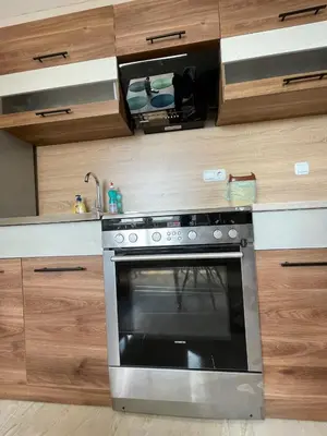a kitchen with a stainless steel oven and wooden cabinets at Sea Diamond 2 in Sunny Beach