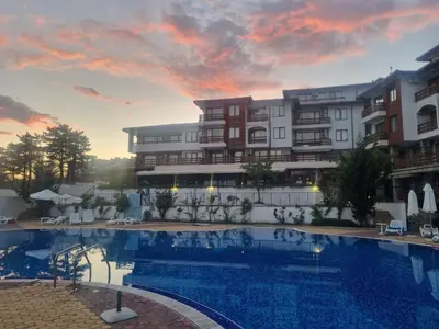 a hotel with a swimming pool in front of a building at Apartamenty na Zielonych Wzgórzach in Sunny Beach