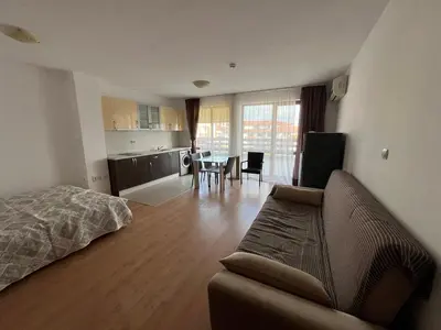 a living room with a couch and a table with chairs at Apartamenty na Zielonych Wzgórzach in Sunny Beach