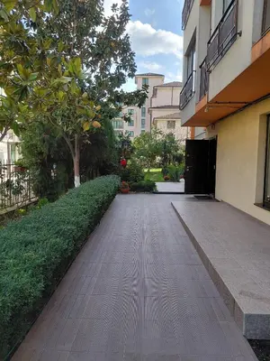 a walkway in front of a building with a tree at 2 Zimmer Wohnung in Sunny Beach in Sunny Beach