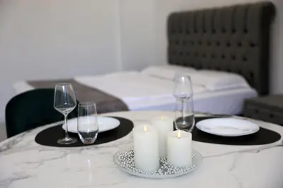 a table with candles and wine glasses on it at Студио in Burgas City
