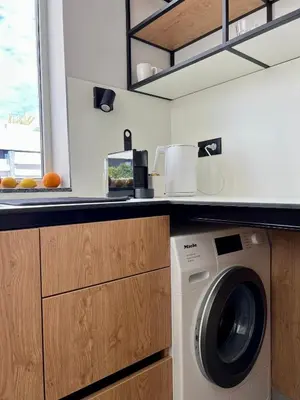 a kitchen with a washing machine under a counter at Slow Living House in Lozenets