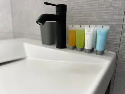 a sink with a faucet and four different colored glasses at Slow Living House in Lozenets