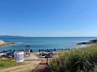 a beach with chairs and umbrellas and the ocean at Slow Living House in Lozenets