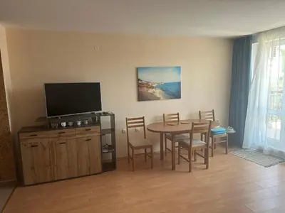 a living room with a table and a television at Amartmán přímo u moře - Elenite až 5 osob in Sveti Vlas