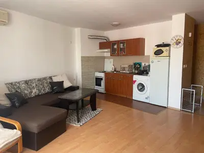 a living room with a couch and a kitchen at Amartmán přímo u moře - Elenite až 5 osob in Sveti Vlas