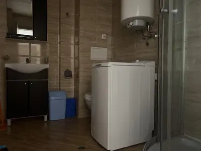 a bathroom with a toilet and a white refrigerator at PREMIER HOUSE BEACH Hotel in Sveti Vlas