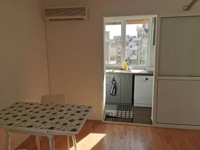 a kitchen with a table and a table and a window at Emona 5 floor 4 in Burgas City