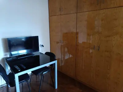 a room with a desk with a television and chairs at Апартамента на центъра на Варна до фонтаните и морето и градинта in Varna City