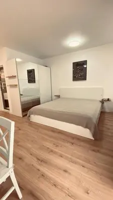 a bedroom with a large bed and a chair at Sveti Vlas, Rodopi Bay Apartment in Sveti Vlas