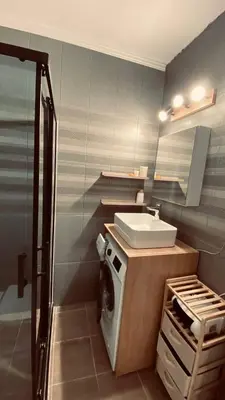 a bathroom with a sink and a washing machine at Sveti Vlas, Rodopi Bay Apartment in Sveti Vlas