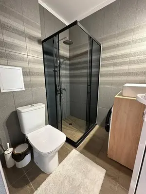 a bathroom with a shower and a toilet and a sink at Sveti Vlas, Rodopi Bay Apartment in Sveti Vlas