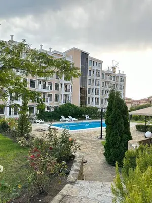 a large building with a swimming pool in a yard at Sveti Vlas, Rodopi Bay Apartment in Sveti Vlas