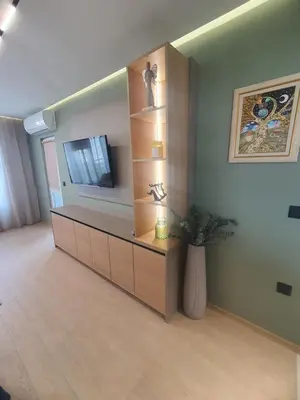 a living room with a cabinet with a tv on it at Divalla Apartment Burgas in Burgas City
