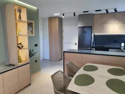 a kitchen with a counter and a table with chairs at Divalla Apartment Burgas in Burgas City