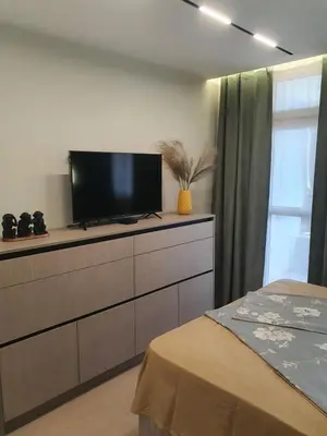 a bedroom with a dresser with a flat screen tv on it at Divalla Apartment Burgas in Burgas City