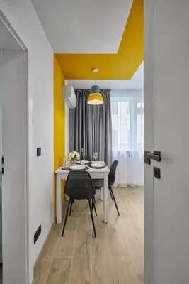 a dining room with a table and chairs and a yellow ceiling at Sea Moreto Apartment 3 in Burgas City
