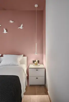 a bedroom with pink walls and a bed and a nightstand at Sea Moreto Apartment 3 in Burgas City