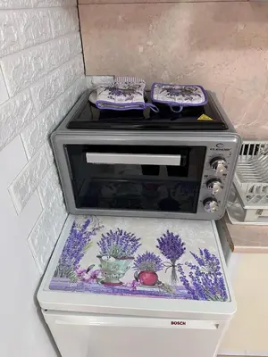 a stove top with a bowl of flowers on it at House Velevi in Sveti Vlas