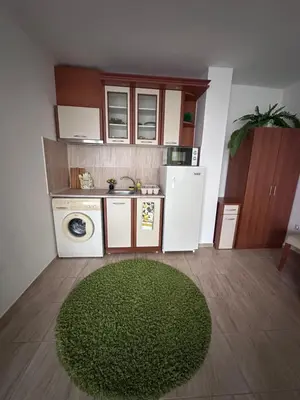 a small kitchen with a green rug in a room at House Velevi in Sveti Vlas