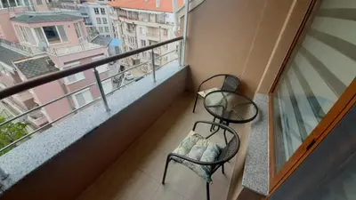 a balcony with a chair and a view of a city at Apartment Tuthon in Pomorie