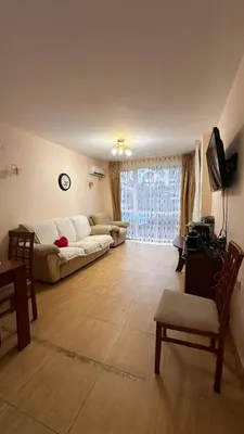 a living room with a white couch and a television at Sveti Vlas, Paradise Dreams Apartment in Sveti Vlas