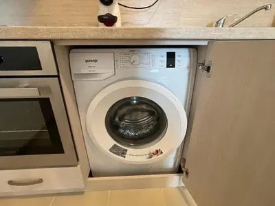 a washing machine in a kitchen under a counter at Fortuna Cape 4 apartment in Byala