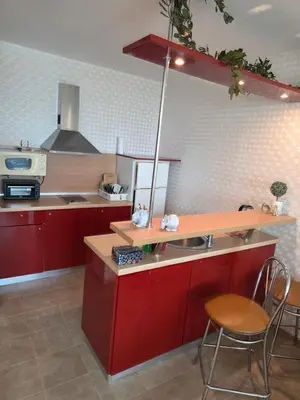 a kitchen with red cabinets and a table and chairs at Apartament Hotel Miramar Palace in Sunny Beach