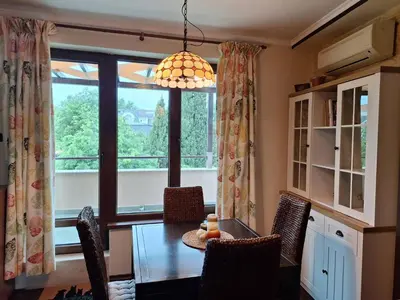 a dining room with a table and a large window at Veneto Apartment in Varna City
