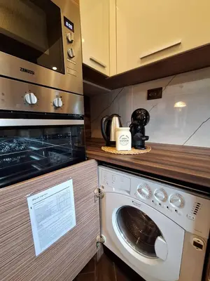 a kitchen with a microwave and a washing machine at Veneto Apartment in Varna City
