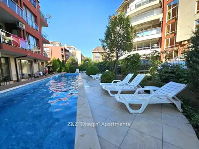 a row of white lounge chairs next to a swimming pool at Z&Z 