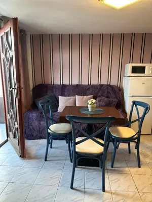 a table and chairs in a room with a couch at Villa Nikoleta in Sveti Vlas