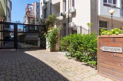 a street with buildings and a sign on a sidewalk at Делукс Апартамент Лазур Поморие in Pomorie