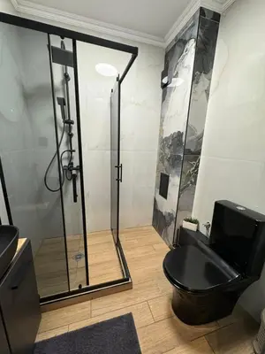 a bathroom with a shower and a black toilet at La Terrassa 7 in Burgas City
