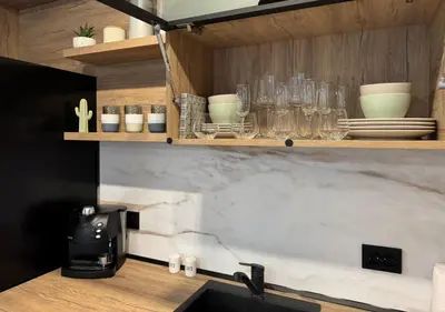 a kitchen with a counter with glasses on shelves at La Terrassa 7 in Burgas City