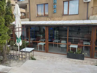a restaurant with tables and chairs and an umbrella at Quiet 1-Bed Flat in Antonia Complex by Flat Mаnager in Sveti Vlas