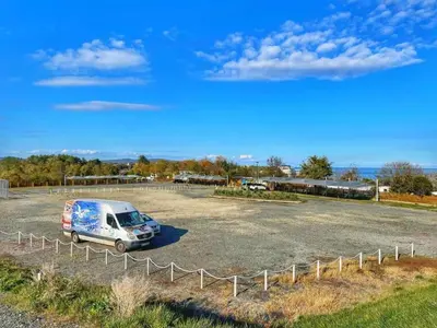a van parked in a parking lot next to a fence at Camping Gardenia - Bungalow SeaBed in Lozenets